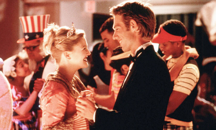 A smiling woman with blond hair (Drew Barrymore) dancing with a man with dark blond hair.