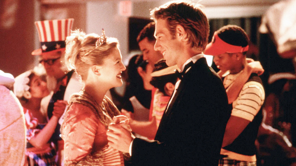 A smiling woman with blond hair (Drew Barrymore) dancing with a man with dark blond hair.