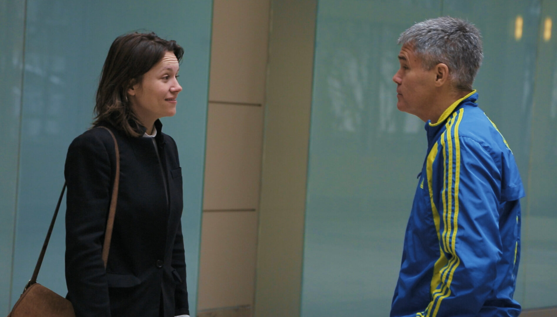 Film still of a daughter and her father looking at each other.