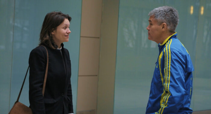 Film still of a daughter and her father looking at each other.