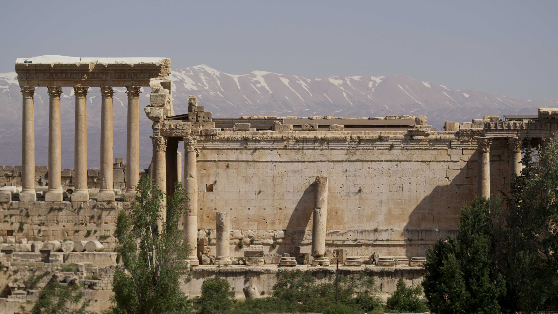 Film still of ancient ruins with columns and mountains behind