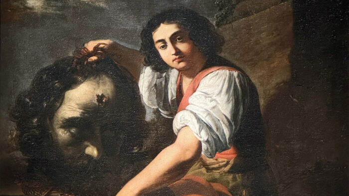 Painting of a young man holding the deceased head of a giant.