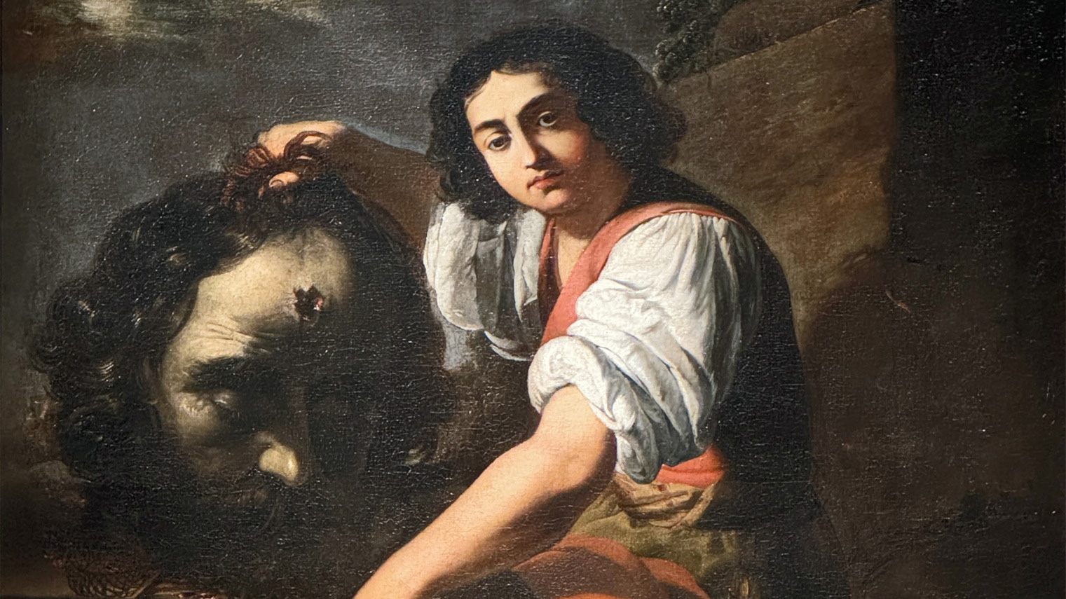 Painting of a young man holding the deceased head of a giant.