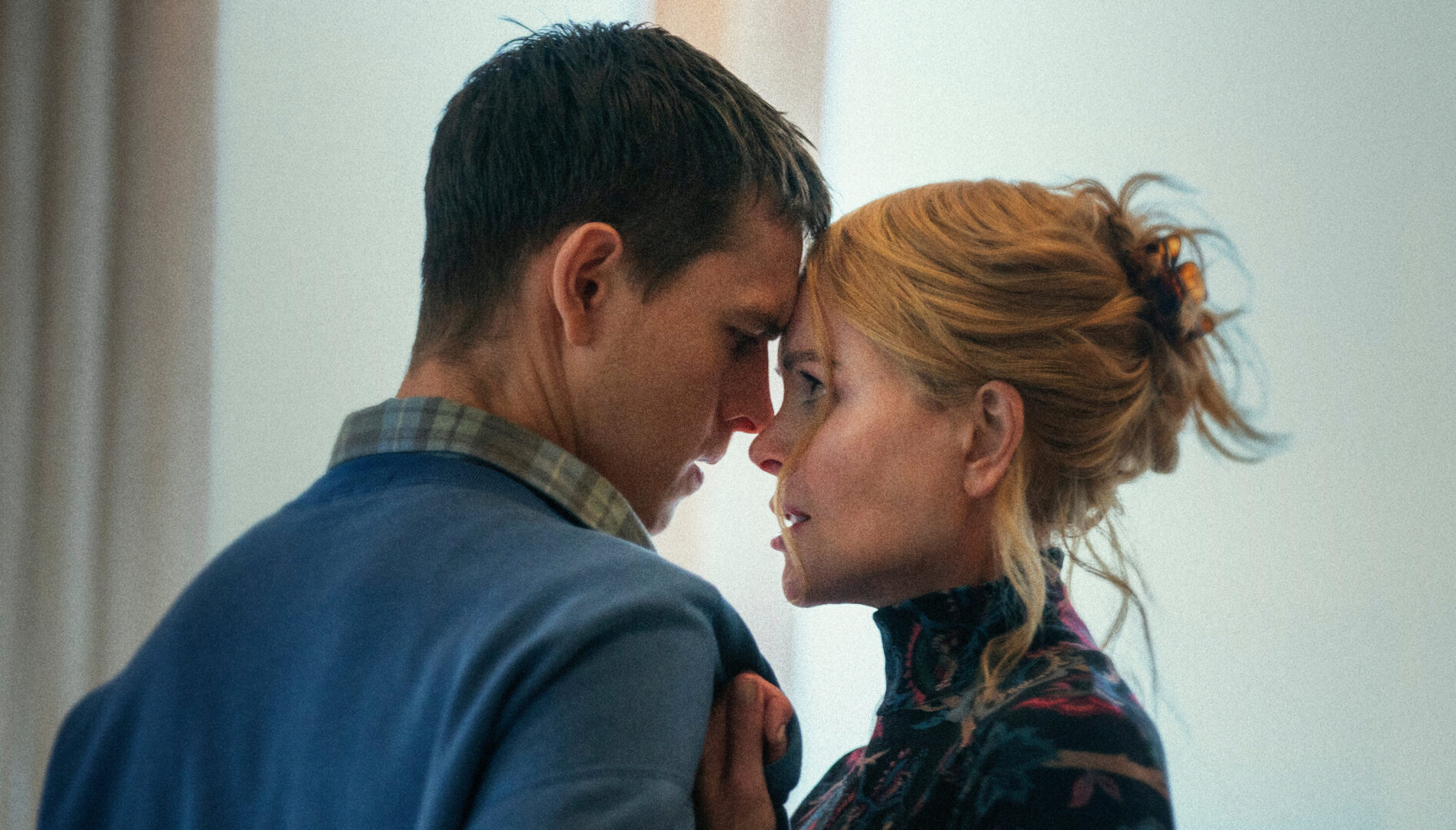 Film still of a man and a woman with their faces very closed together, almost about to kiss.