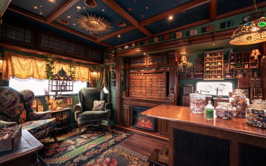 Interior of an old-fashioned room with fancy furnishings and curios on walls and tables.