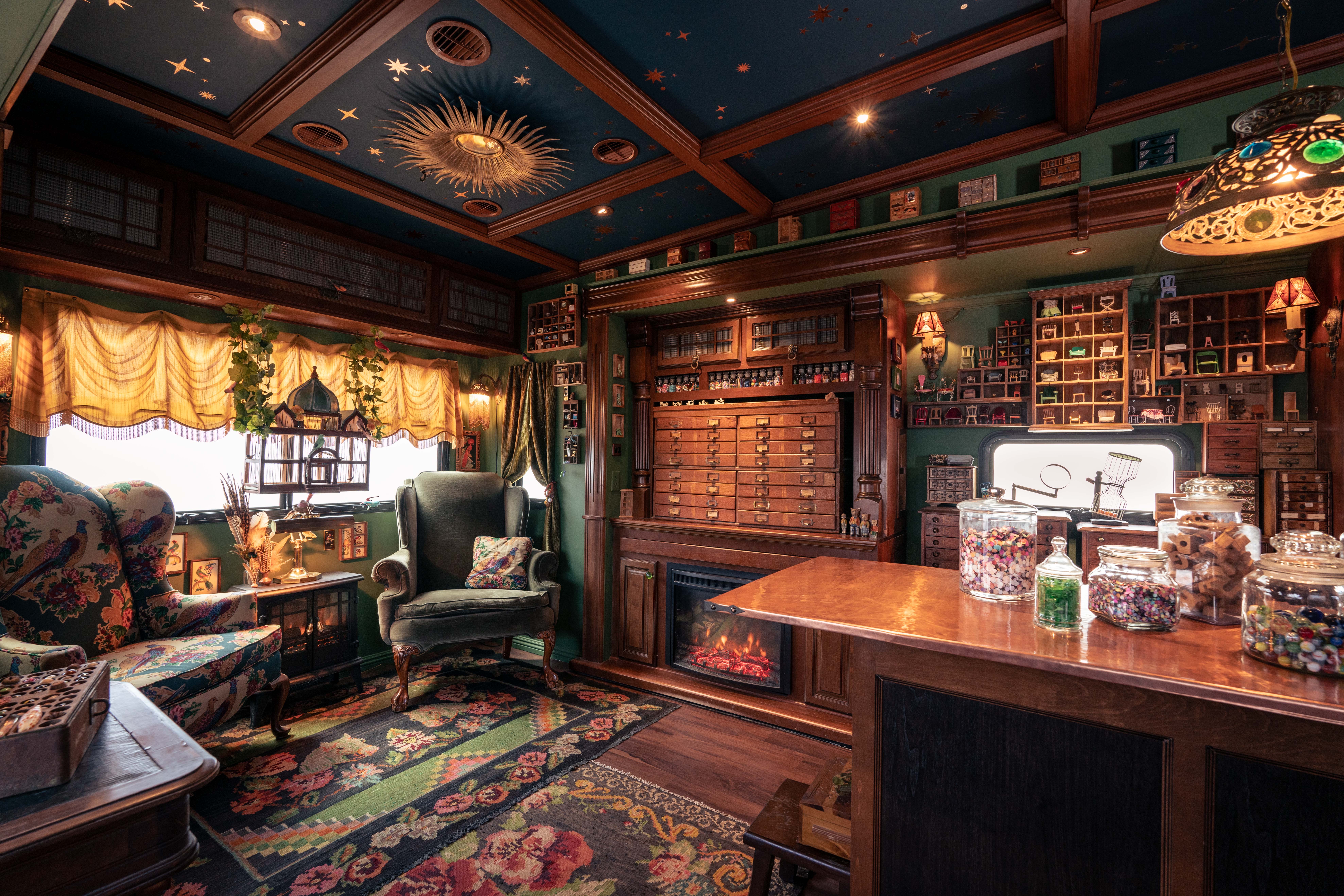 Interior of an old-fashioned room with fancy furnishings and curios on walls and tables.