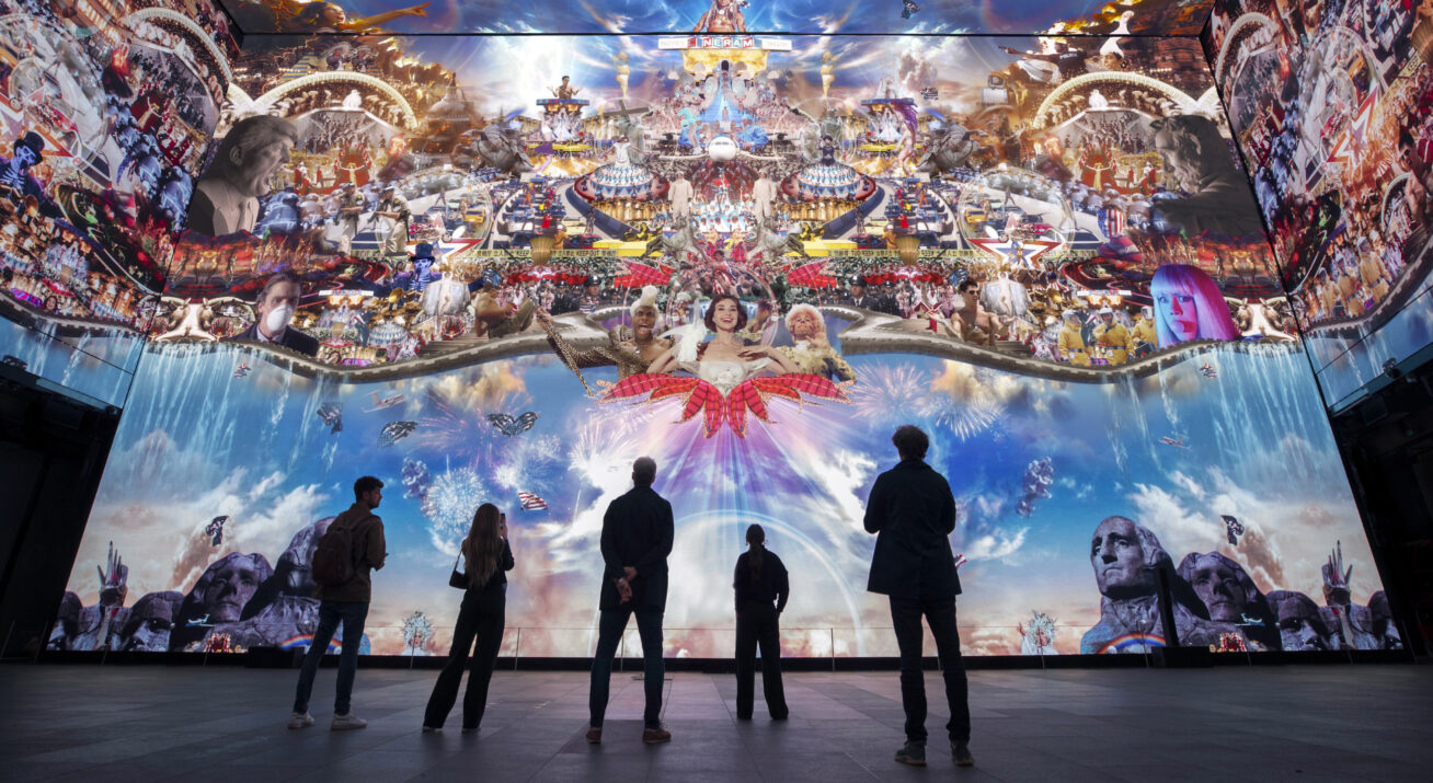 Installation view of a huge video collage with people in shadow at the bottom