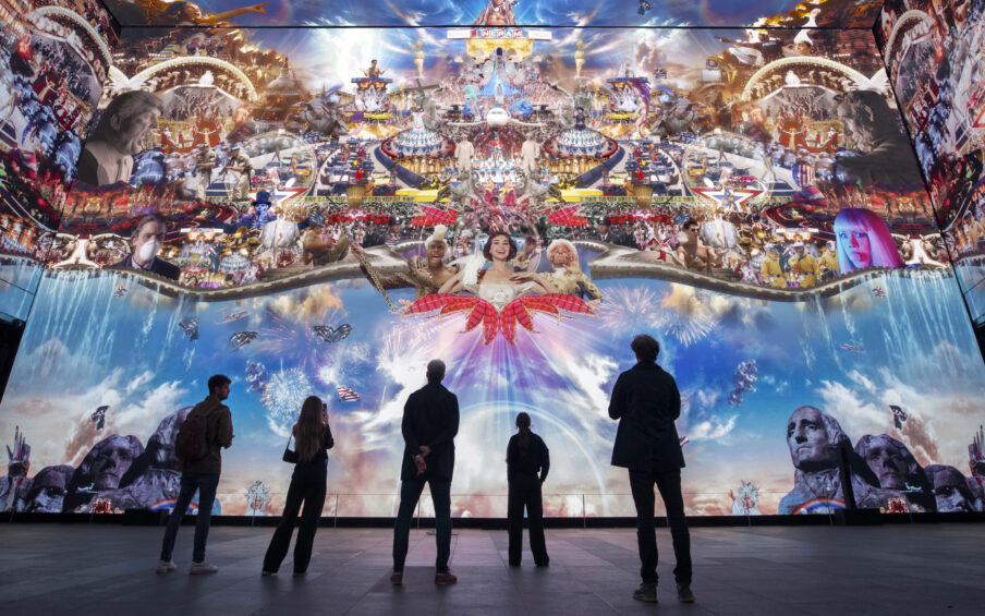 Installation view of a huge video collage with people in shadow at the bottom