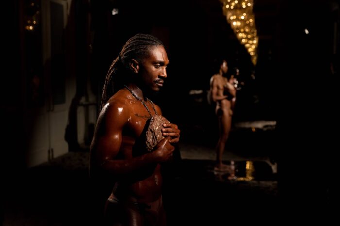 Two people standing in a dark room.