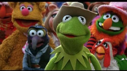 A film still of a group of Muppets with Kermit the Frog in a cowboy hat at the front.