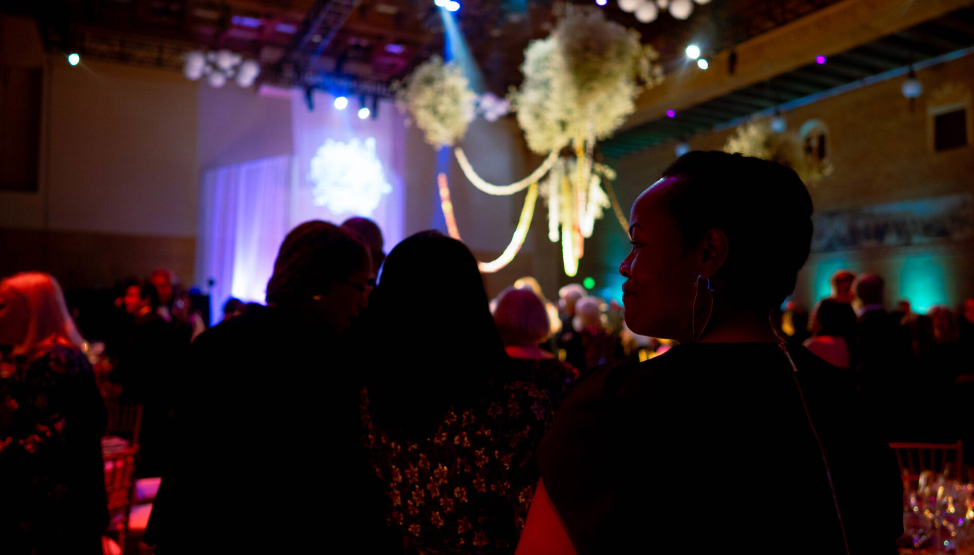 People standing and sitting in a ballroom.
