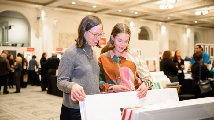 People looking at prints in a large event space.