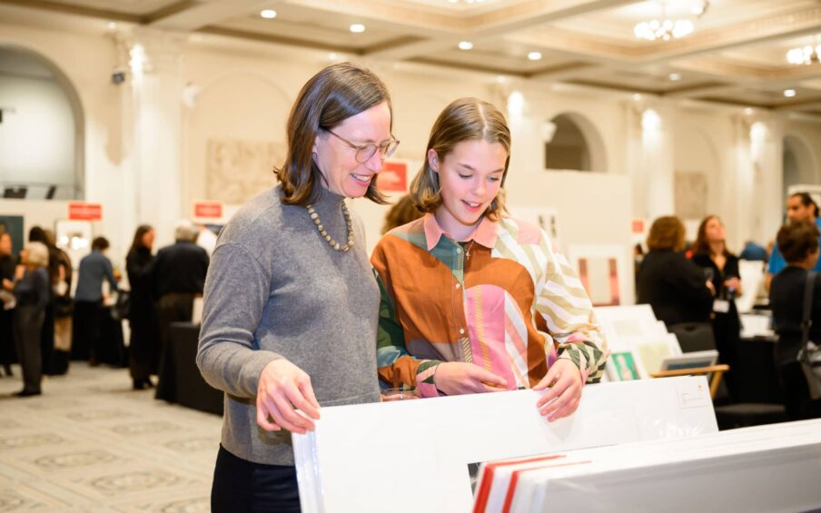 People looking at prints in a large event space.