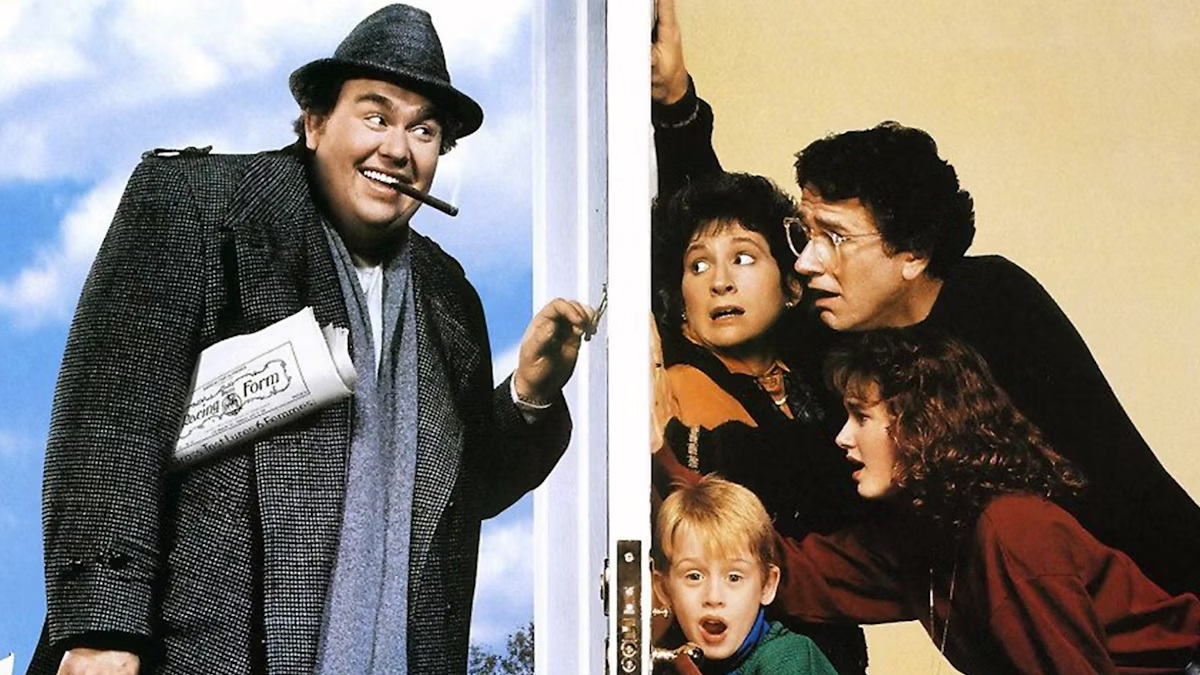 Film still of a man in a trenchcoat, hat, and suit, with a newspaper under his arm and cigar in his mouth, knocking at a white door. On the other side of the door are two adults, a teenager, and a kid looking scared.