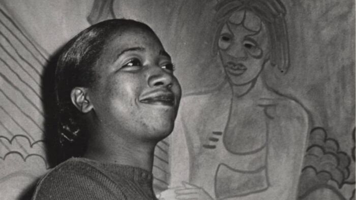 A person standing in front of a painting.