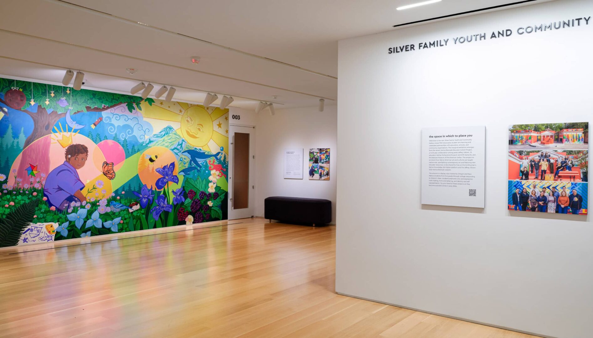 Interior gallery space with a colorful wall mural.