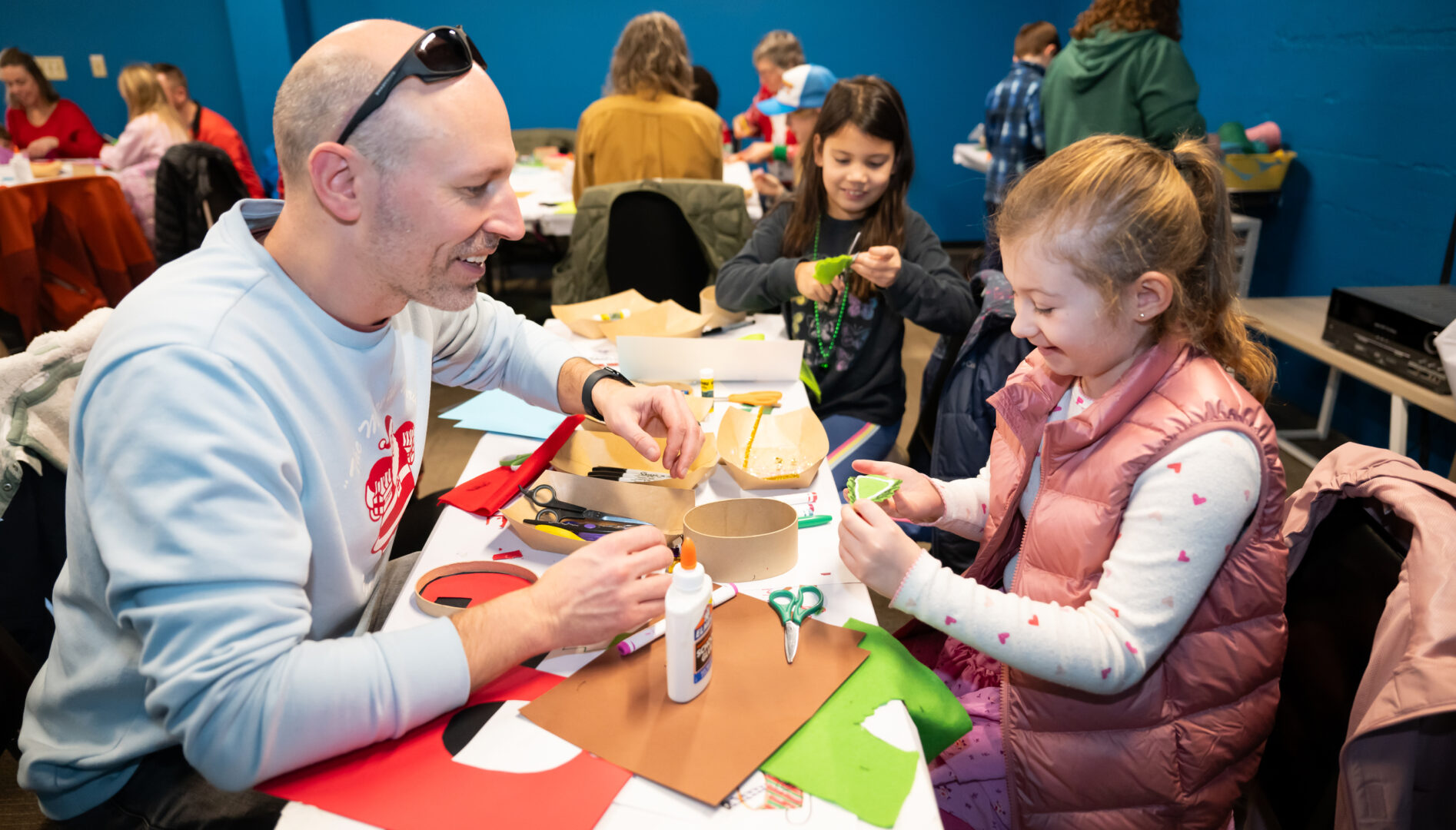 A smiling family working on an art project together.