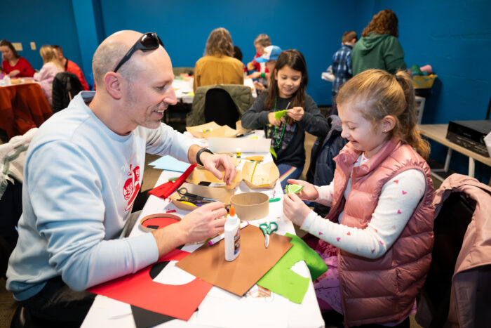 A smiling family working on an art project together.