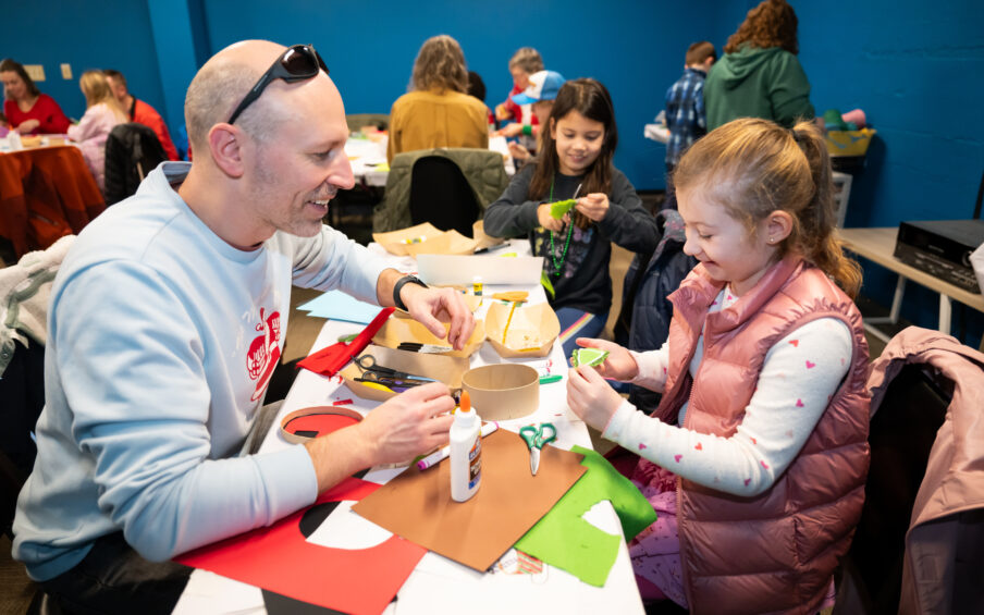 A smiling family working on an art project together.
