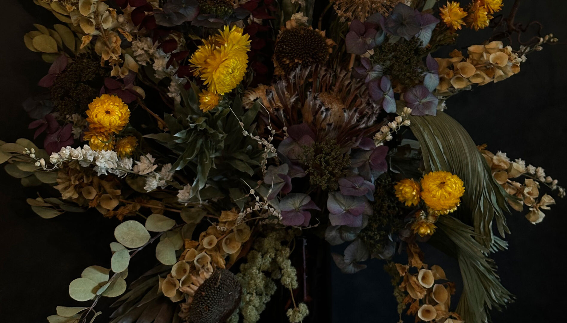 Close up of a dried floral arrangement against a black background