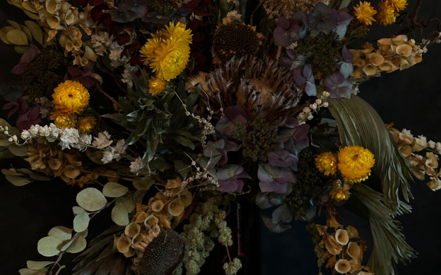 Close up of a dried floral arrangement against a black background