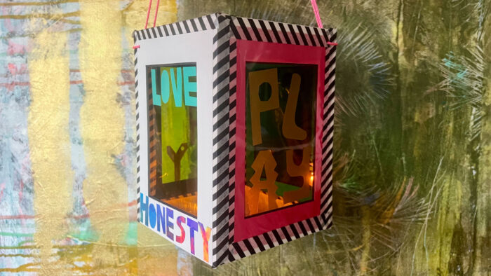 Handmade lantern with the words Love, Honesty, and Play on it