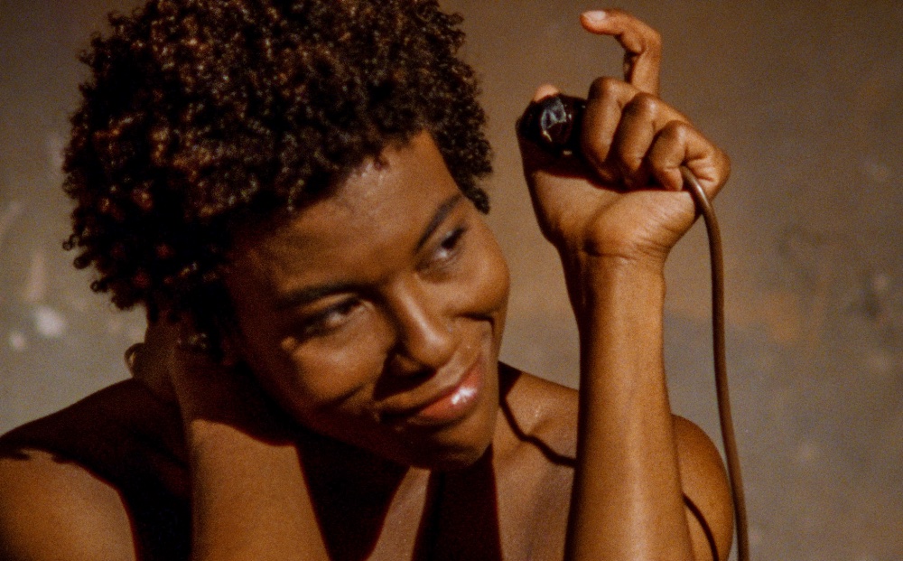 A smiling Black woman holding a microphone