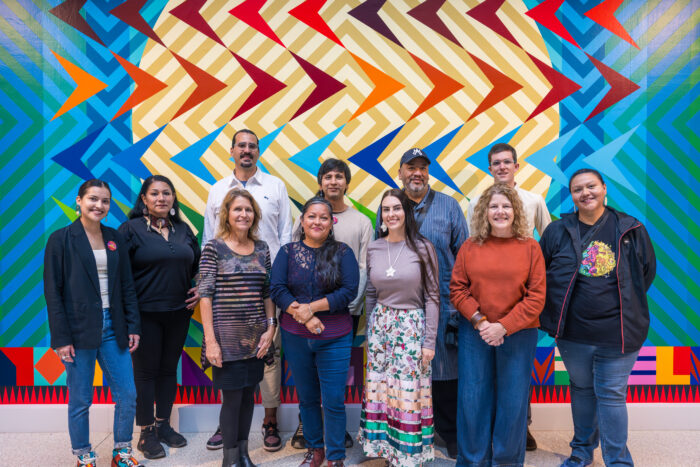 Photo of a group of people in front of Jeffrey Gibson's "BIRDS FLYING HIGH YOU KNOW HOW I FEEL"
