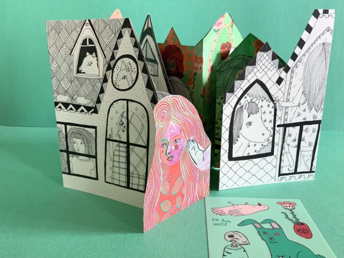 Photo of an illustrated house built of paper.
