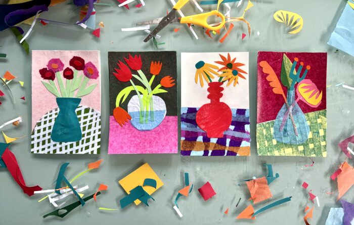 Photo of flower collages with the art tools and paper scraps surrounding them.