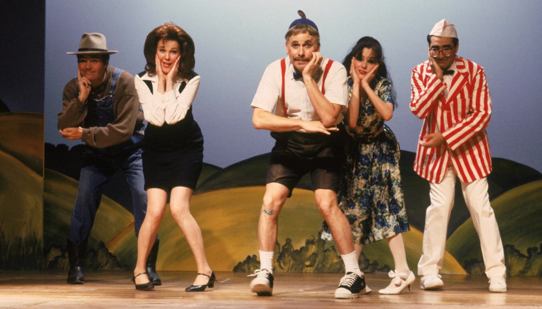 A group of adults acting on a stage.