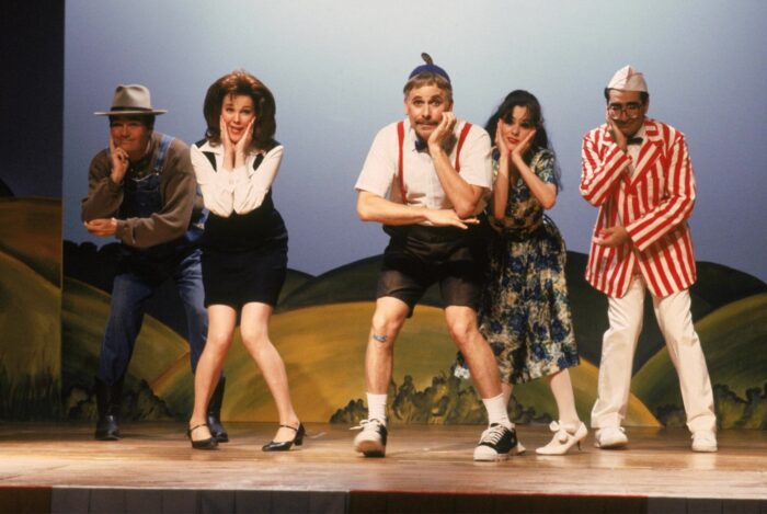 A group of adults acting on a stage.