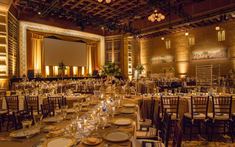 Large ballroom with many tables and place settings.