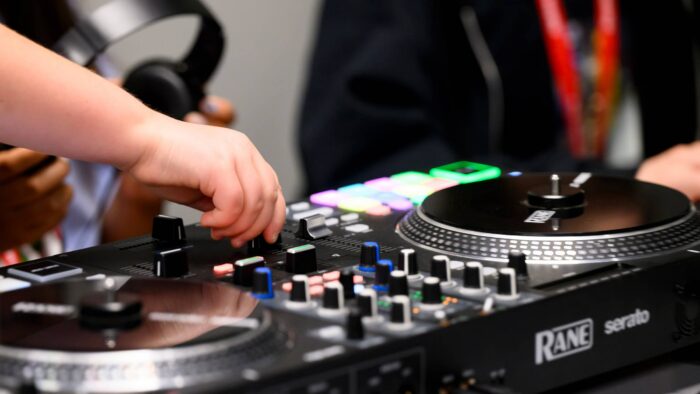 Hands manipulating DJ equipment.
