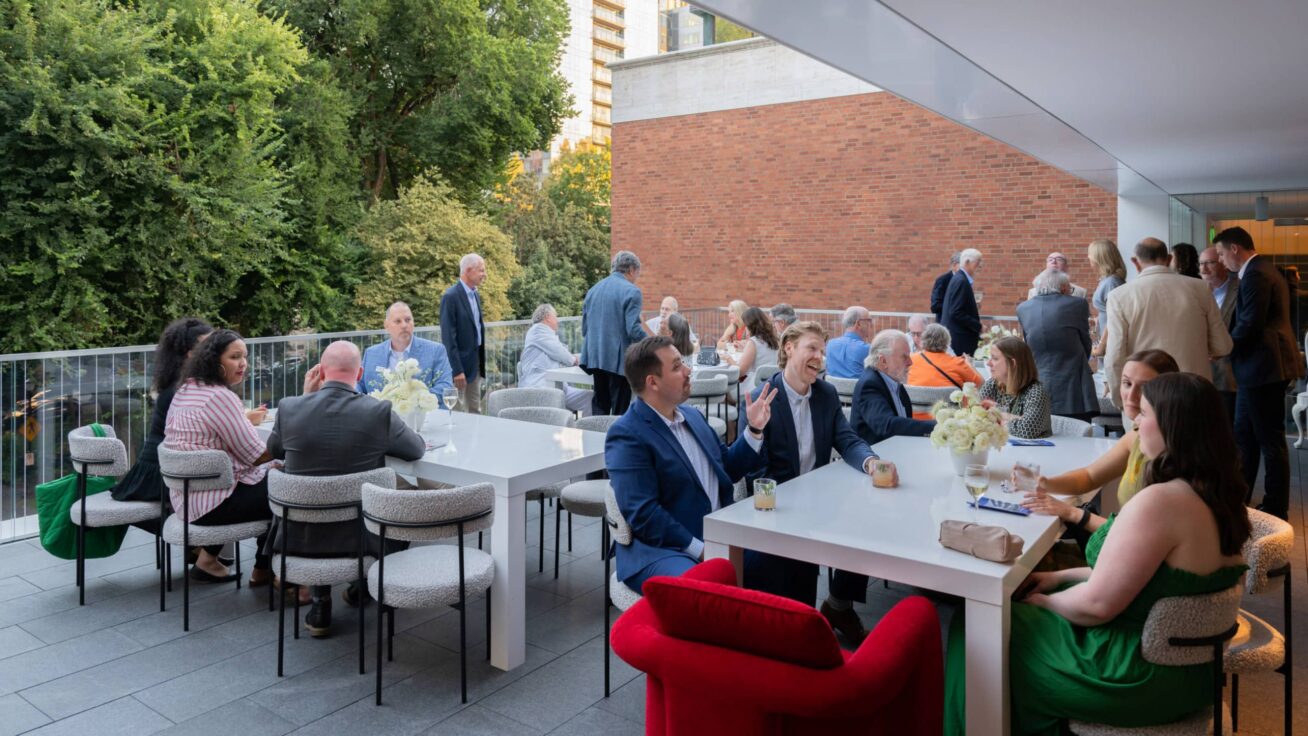 An outdoor terrace with people seated at tables.