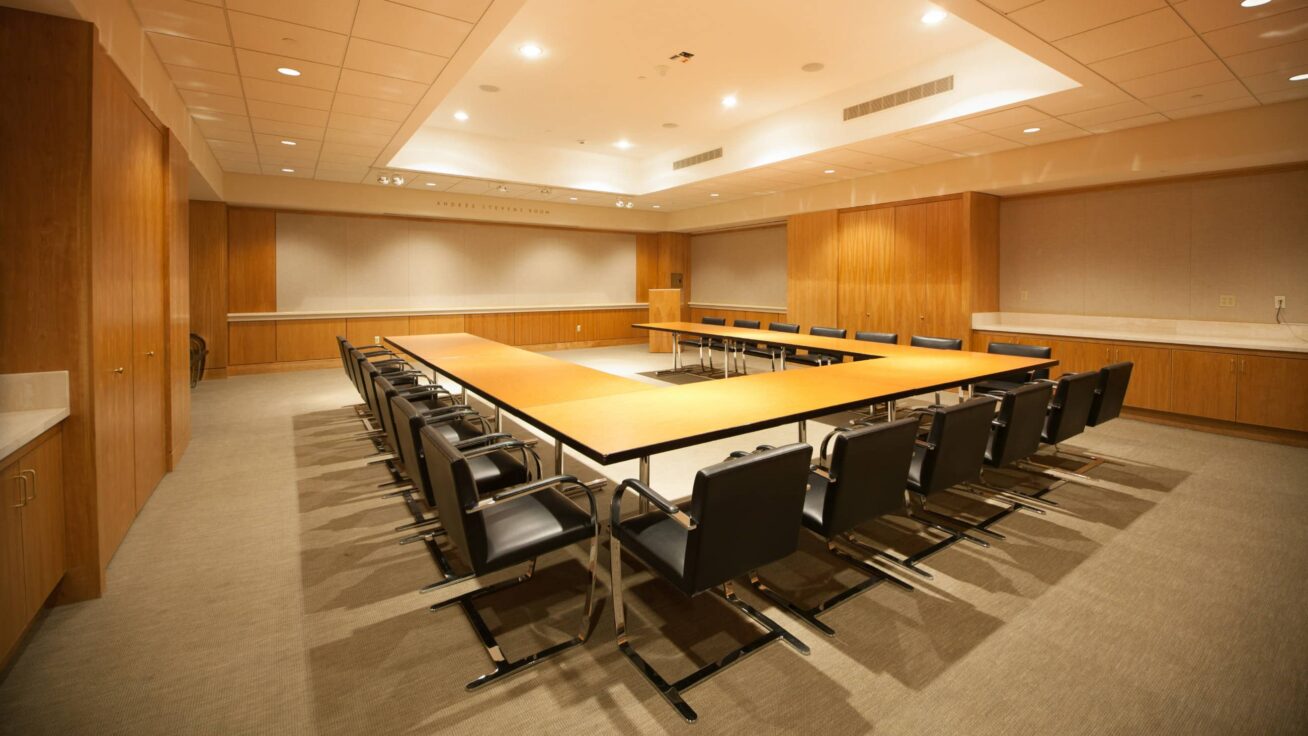 A boardroom with a u-shaped table and chair arrangement.