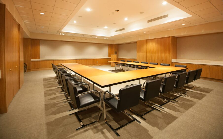 A boardroom with a u-shaped table and chair arrangement.