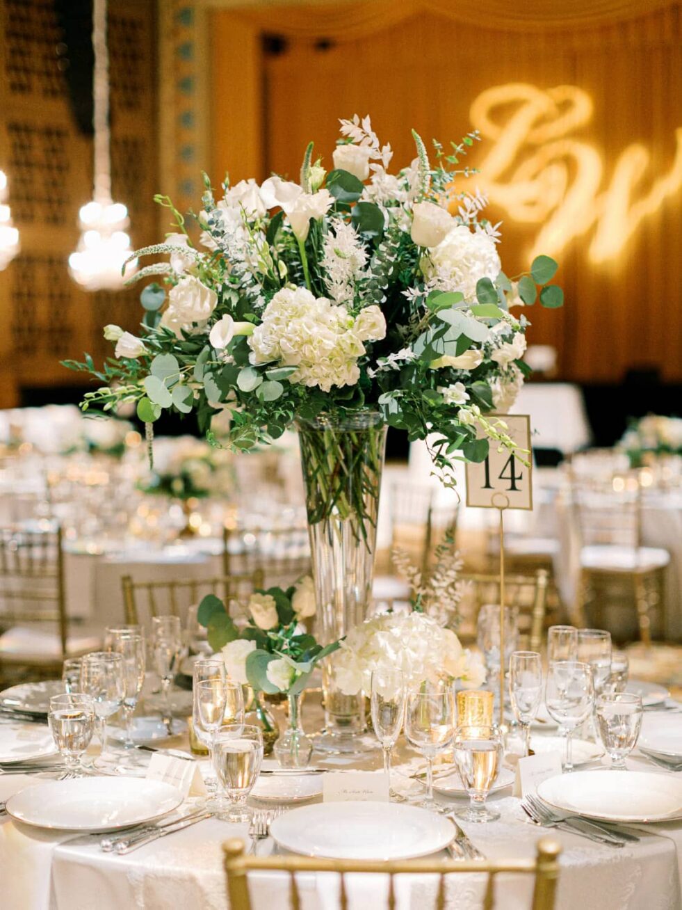 A table with place settings and a bouquet of white flowers.