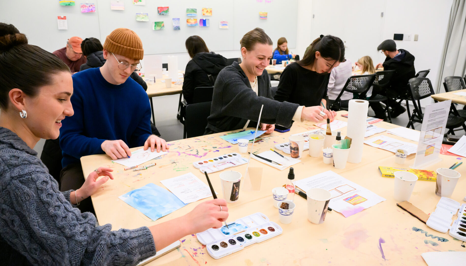 People at a table making art.