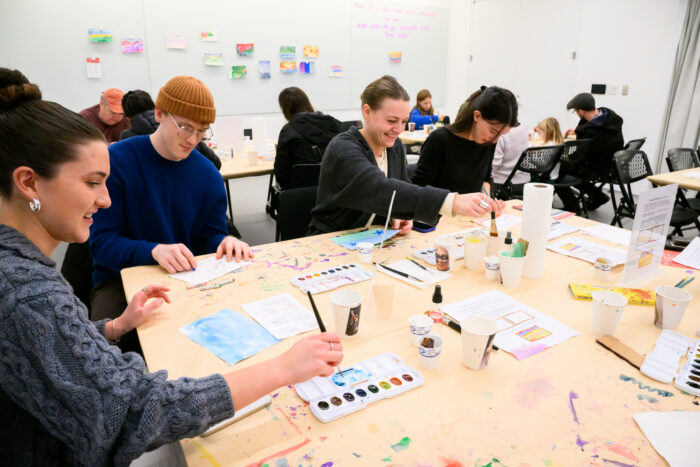People at a table making art.