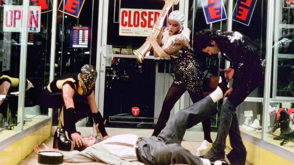 Three people in costumes beating up a man laying on the floor of a business.