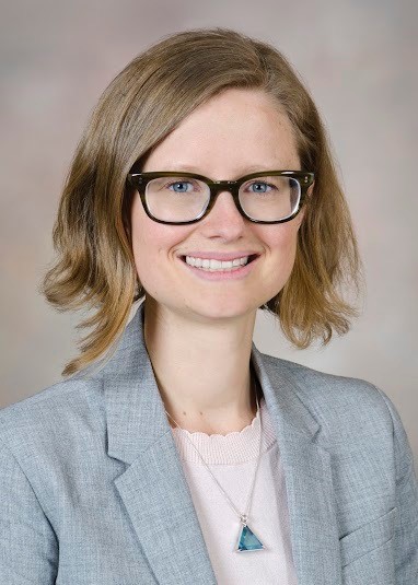 Photo of a smiling woman with mid-length blonde hair, wearing eyeglasses.