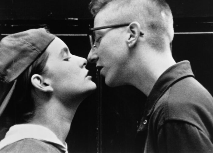 Black and white film still of two women about to kiss.