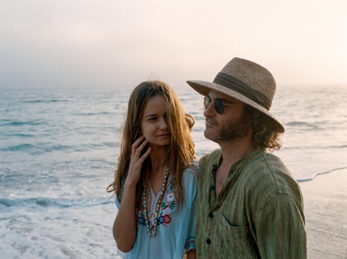 A man and a woman walking on a beach.