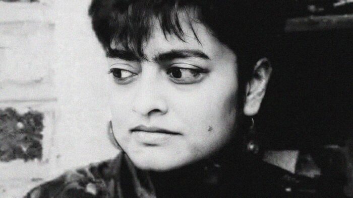 Black and white film still of a woman's face. She is looking to the side.