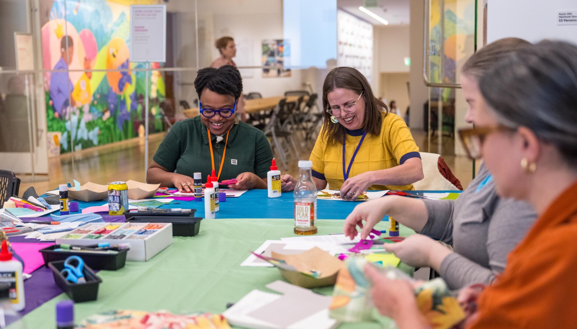Two smiling people working on an art project in the Finley Learning Studio.