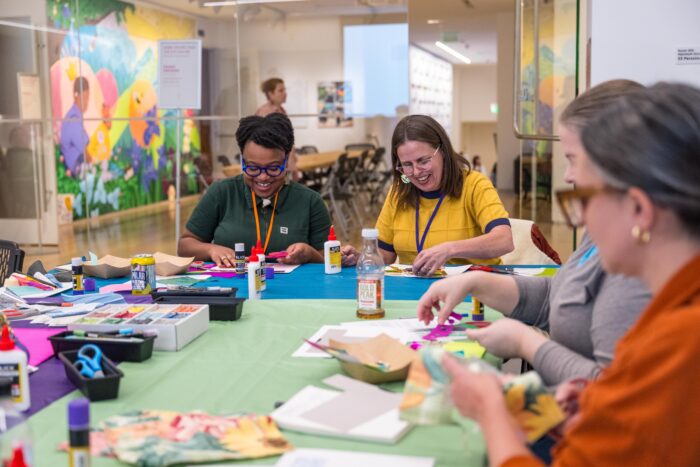 Two smiling people working on an art project in the Finley Learning Studio.