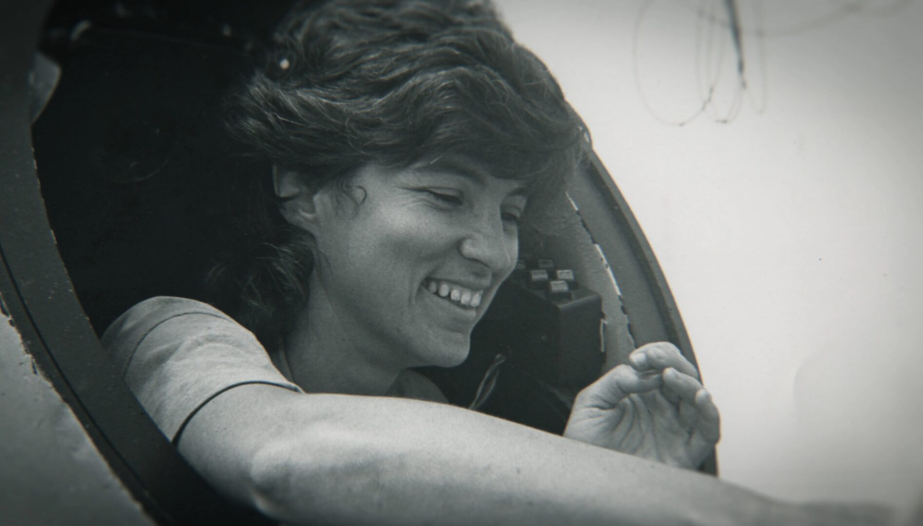 Black and white photo of a smiling woman looking off to the side.