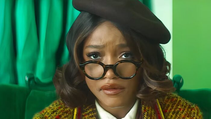 Film still of actress Keke Palmer in a black beret with round black eyeglasses perched on her nose.