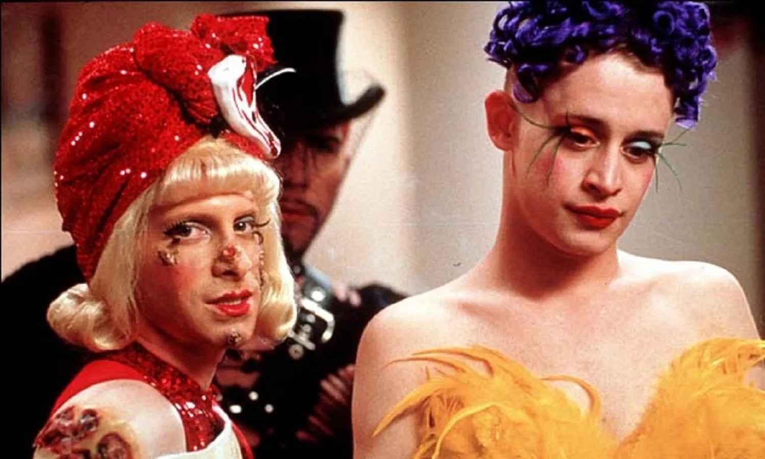 Film still of two people in bright "club kid" costumes.